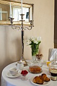 Silver candlestick and vase of tulips on round breakfast table