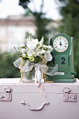 Bouquet of white flowers with orchids next to vintage-style, wooden perpetual calendar