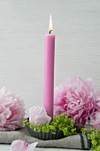 Candle decorated with peonies and lady's mantle