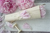 Rolled letter covered in old-fashioned handwriting and filled with peonies