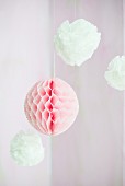 Pompoms and honeycomb paper ball suspended from ceiling