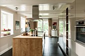 Wood-clad island counter in open-plan kitchen