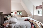 Double bed in bedroom with pastel walls in converted attic