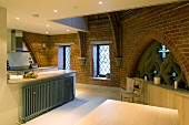 Kitchen with modern installations and Gothic window in converted church