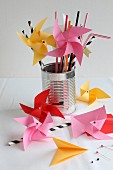 Hand-made origami windmills standing in tin can