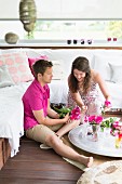 Couple sitting on floor of balcony decorated in Oriental style
