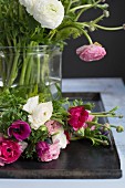 Glasvase mit Blumenstrauss aus Ranunkeln und Anemonen