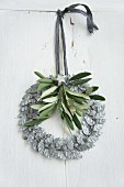 Wreath of silver-grey metal leaves decorated with olive sprig