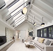 Elongated living room with exposed beams under roof ridge