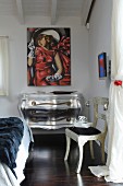 Silver chest of drawers with curved front and legs below modern painting