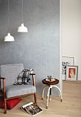 Retro armchair and stool in front of concrete-effect wall