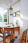 Sunny dining area with drop-leaf table and wooden chairs