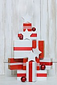 Gifts wrapped in red and white stacked in shape of Christmas tree