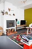 Yellow wall and multicoloured rug in colourful living room