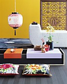 Niedriger Asia-Tisch mit Bodenkissen vor Polstermöbel und gelber Wand