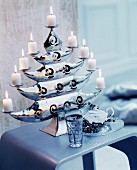 Lit white pillar candles on elegant candle holder shaped like a tree