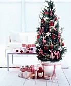 Presents under small potted conifer decorated with red and white gingham animals and red baubles