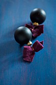 Black Christmas-tree baubles with felt ribbons