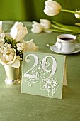 Decorative place card with number 29 on festive table