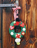 Hand-crafted Christmas wreath with love-heart motifs hung on wooden door