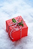 Red-wrapped gift amongst snow