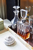 Elegant crystal carafes on tray next to hand-carved stone box