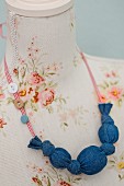 Necklace made from denim-covered beads and ribbon