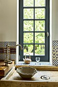 Traditional sink unit with vintage tap in front of lattice window