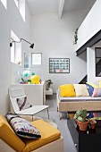Wohnzimmerecke mit bunten Kissen auf Sitzmöbeln und Galerieebene