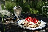 Strawberry cake and crockery on garden table