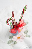 Festive candy canes tied with ribbon arranged in glass