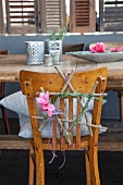 Star made from twigs decorated with rosemary and cyclamen on chair backrest