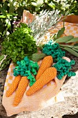 Hand-made crocheted carrots and fresh herby on tea towel