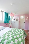 Pink wallpaper and turquoise curtains in attic bedroom