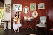 Bride holding bouquet sitting in vintage-style waiting room