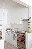 White cupboards and transparent storage boxes in small kitchen