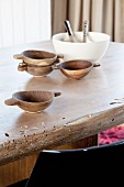 Wooden bowls and bowl of salad on rustic dining table