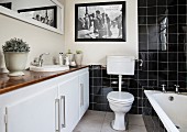 Badezimmer mit schwarzen Fliesen und breitem Waschtisch
