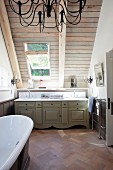 Country-house-style washstand and free-standing bathtub in attic bathroom