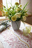 Vase of flowers and table runner printed with traditional floral motif