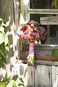 Bouquet of astrantia and marjoram flowers wrapped in ribbon