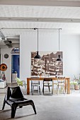Various chairs in front of large vintage-style photo and view of entrance area in loft apartment