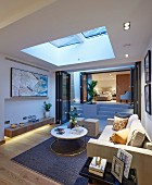 Illuminated living room with skylight and view into bedroom