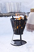 Fire basket amongst snow for winter picnic