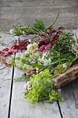 Autumnal arrangement of flowers and leaves on rustic wooden surface