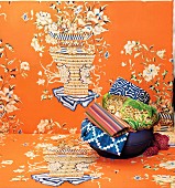 Eine Schale mit bunten Ethno-Textilien auf orangenem Stoff