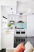 Open kitchen with white furniture and black floor