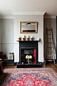 Open fireplace with cast iron surround in chimney breast flanked by niches