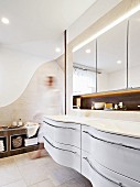 Geschwungener, weißer Waschbeckenunterbau in elegantem Designerbad