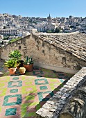 Geometric tiles on Mediterranean roof terrace with view of city